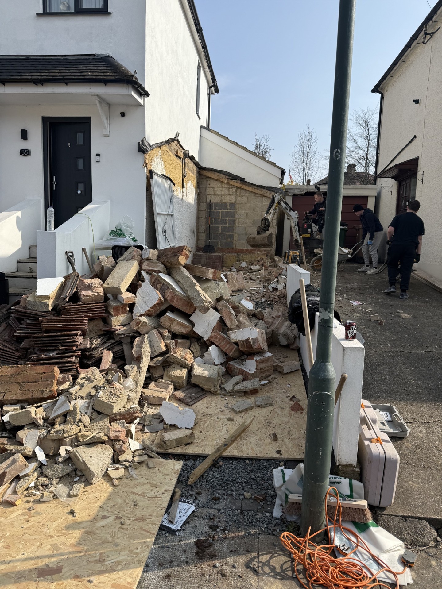 Garage demolition and cleared masonry beside the existing home